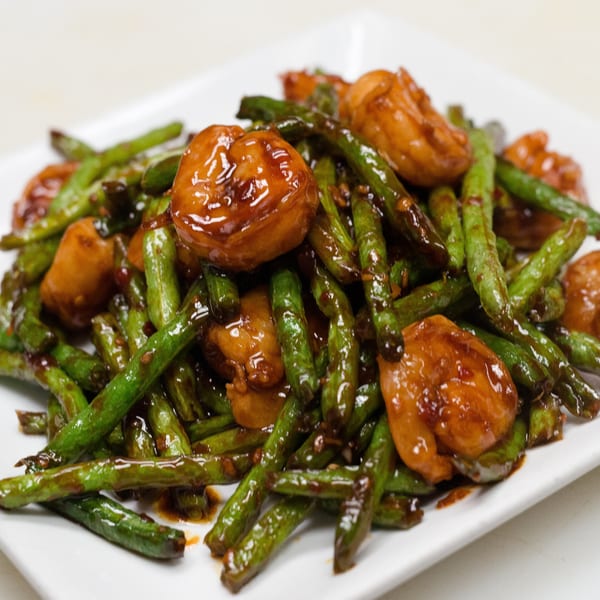 Go China Restaurant's stir-fried green beans and chicken in a glossy brown sauce on a white plate.