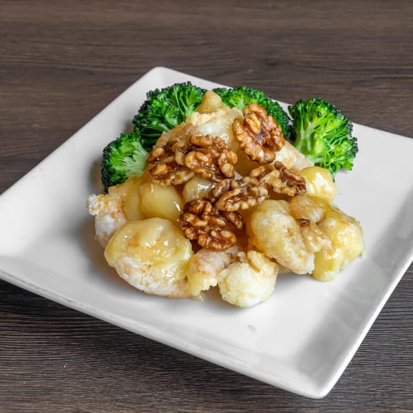 Honey walnut shrimp with broccoli florets on a white rectangular plate at Go China Restaurant.